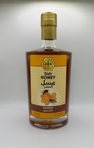 زجاجة عسل السدر الكشميري بحجم 1000 غرام، تظهر الزجاجة الطويلة والأنيقة بلونها العنبري الغامق وملصق يحمل اسم المنتج ومنشأه